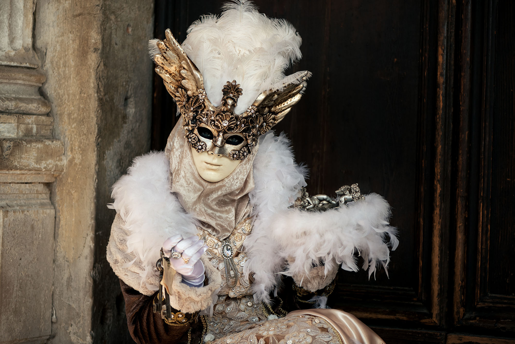 woman in Venetian carnival costume against the wall