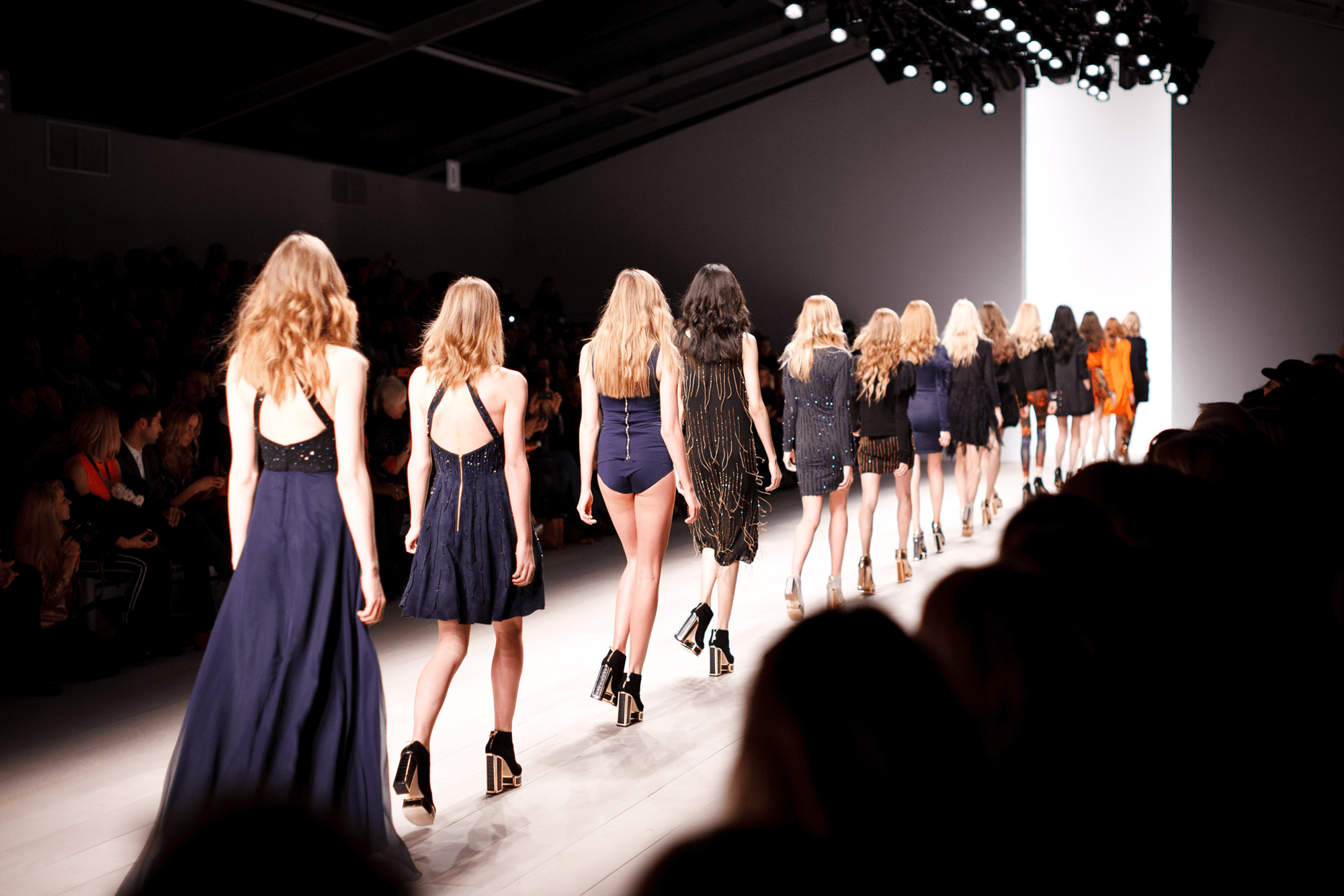 image of line of models on catwalk walking away