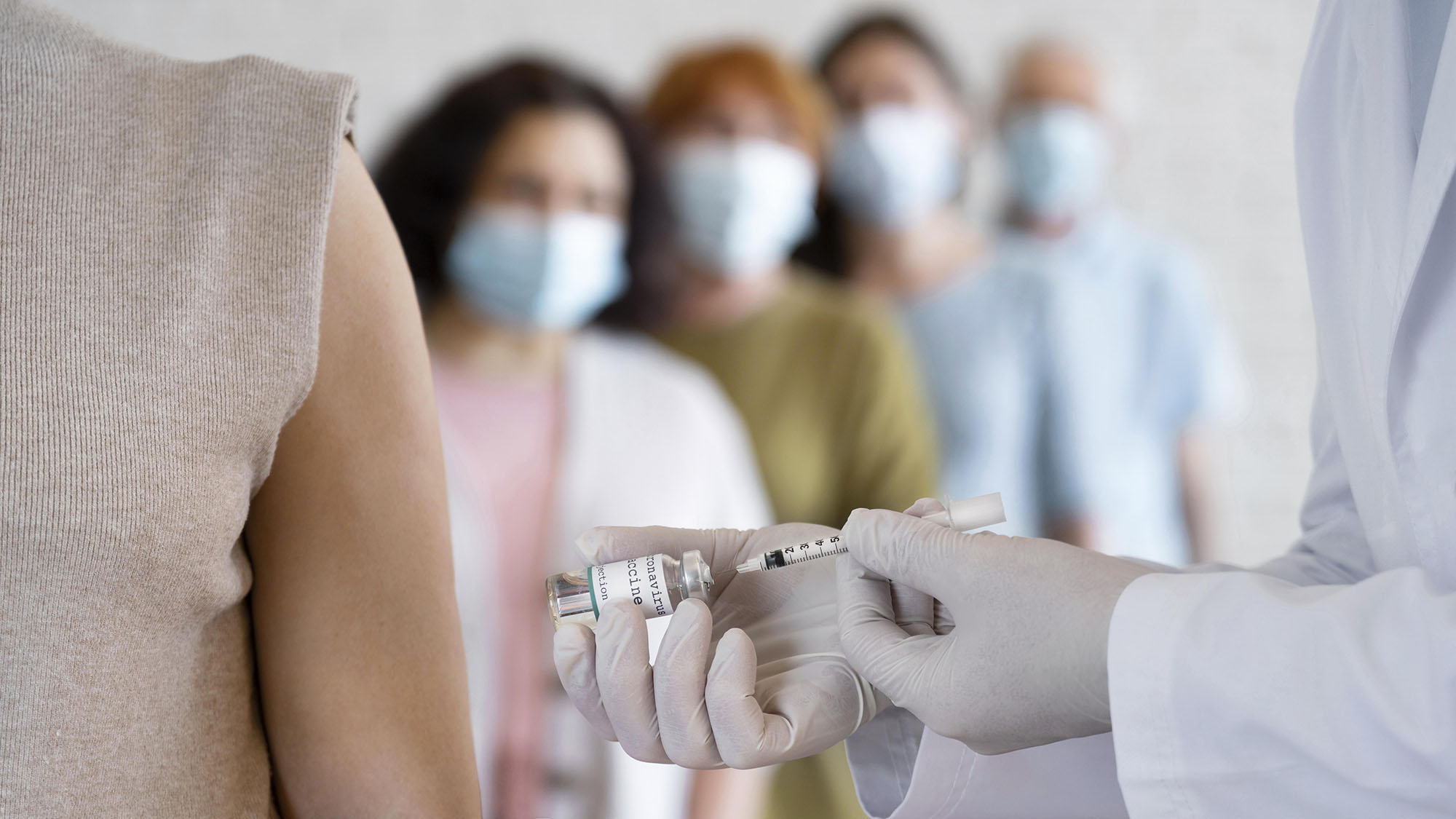 image of people standing in queue for a vaccine