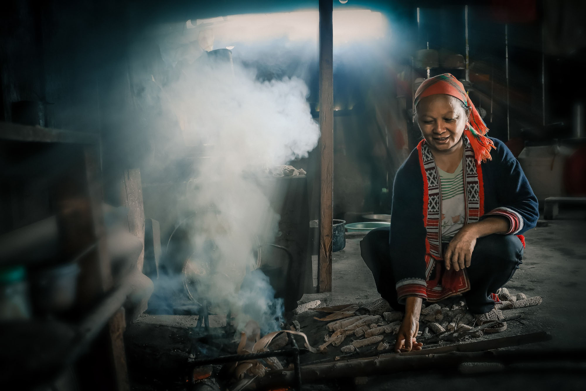 Vietnam woman swatting beside coal fire