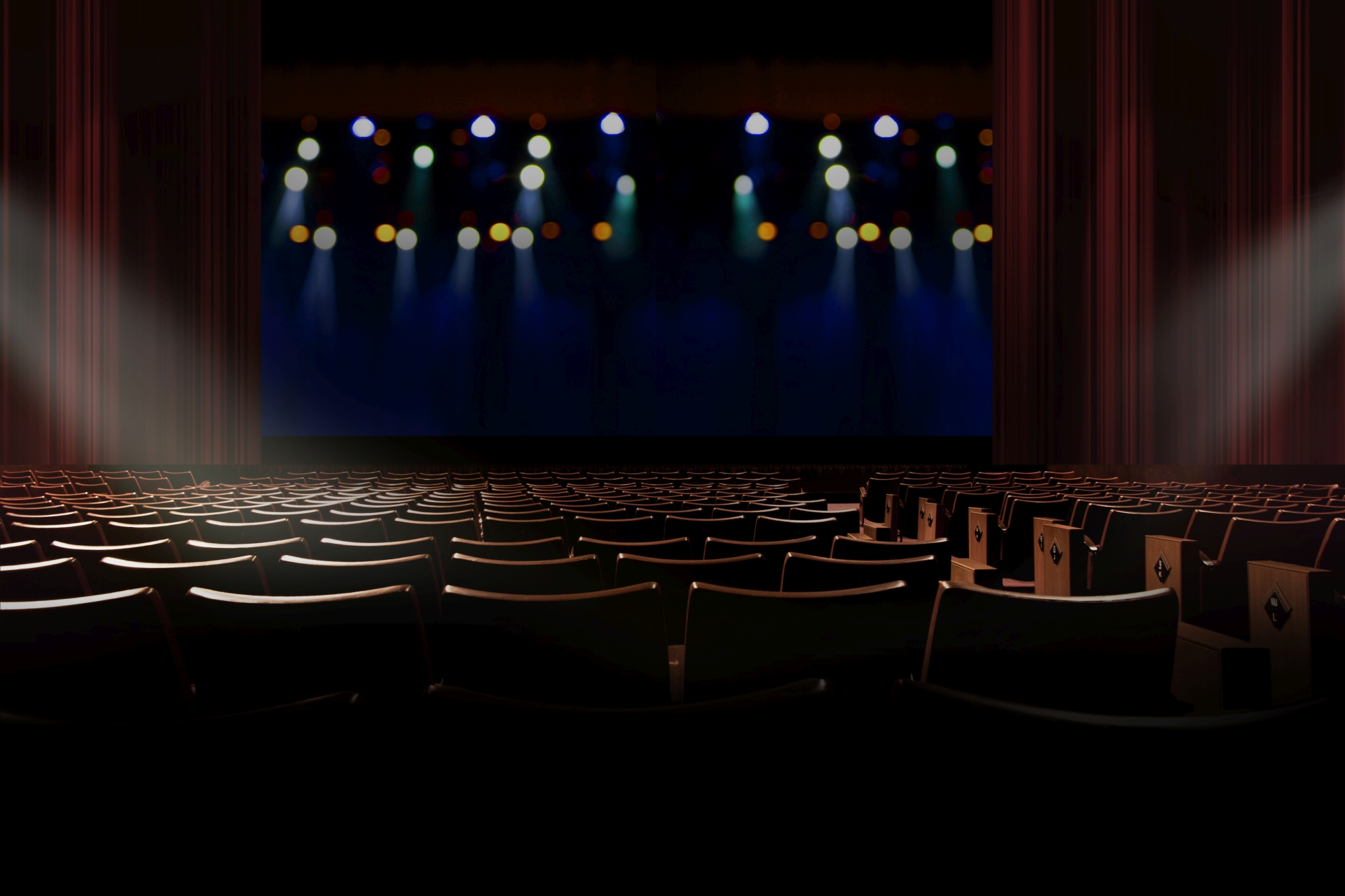 image of movie theatre and lights on its dark screen