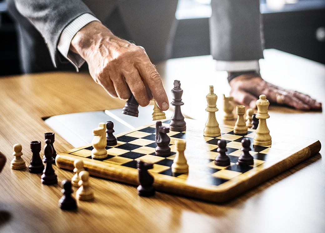 chessboard with pieces and hands moving one