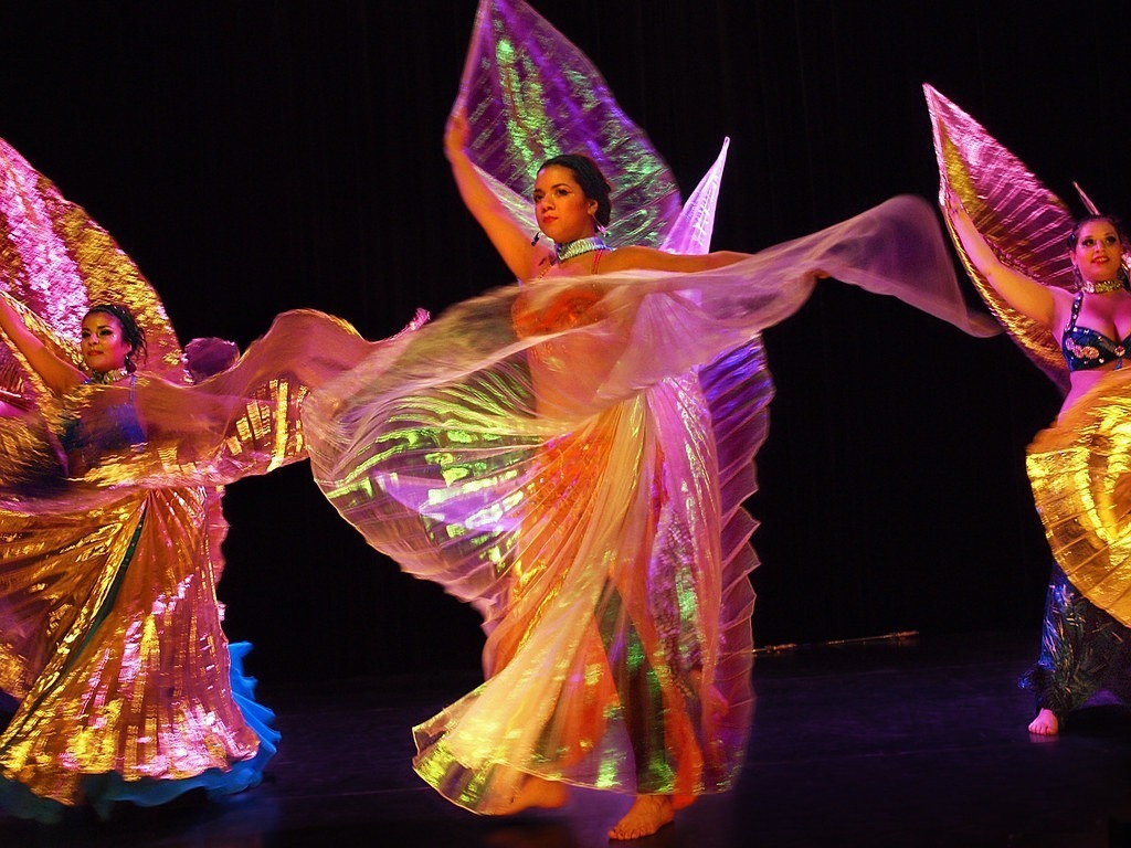 image of women dancing with scarfs on dark background