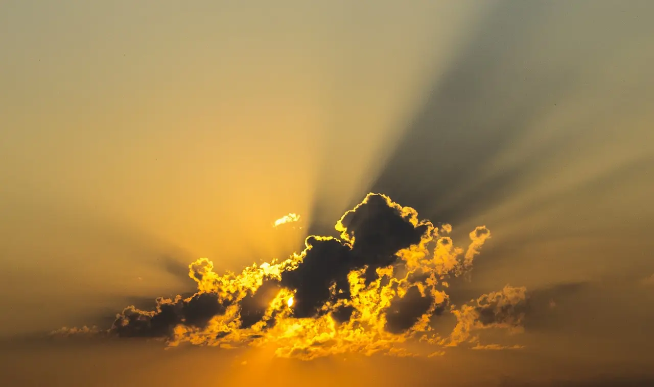 Image of a cloud in the sky at dusk, with sunlight behind it.
