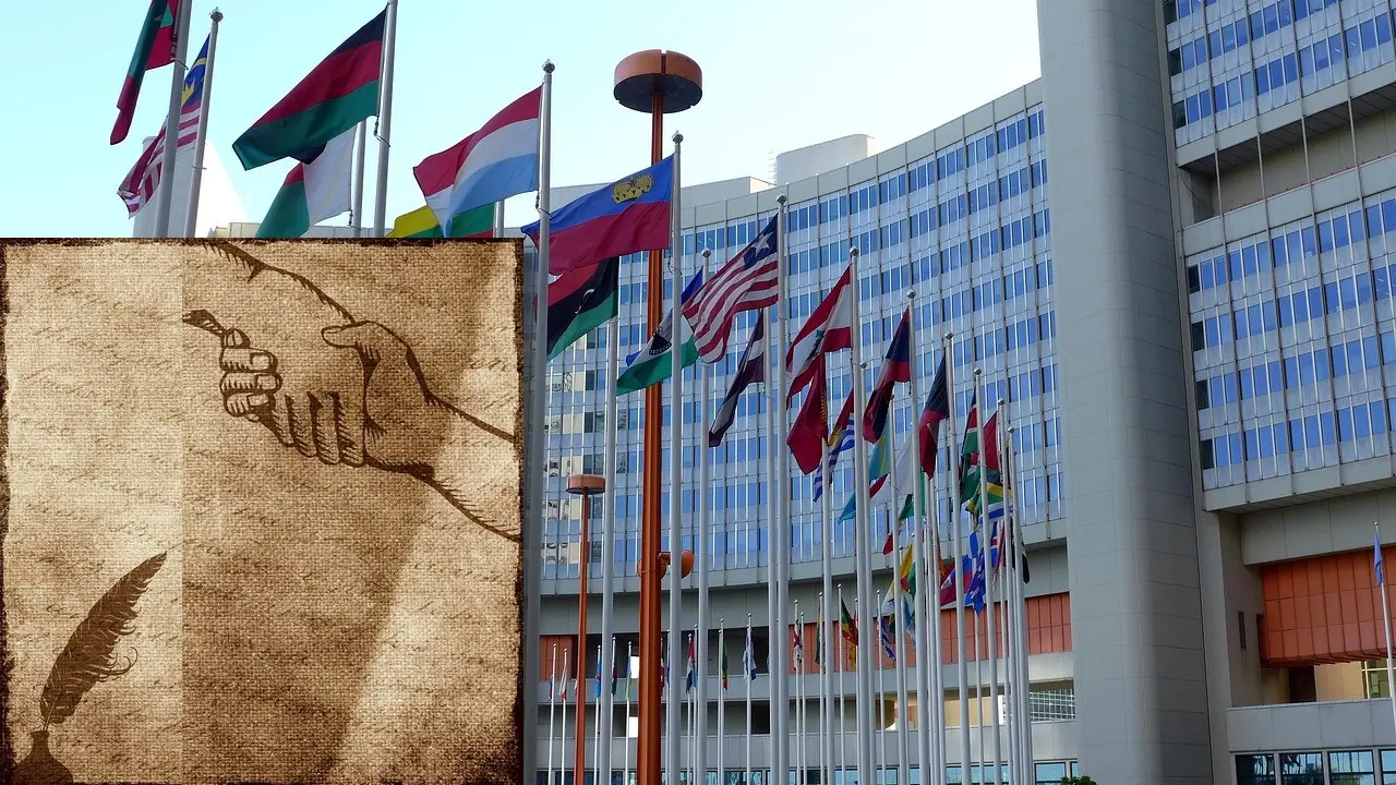 Picture of the UN building in Vienna in front an ancient scroll shape showing two shaking hands.