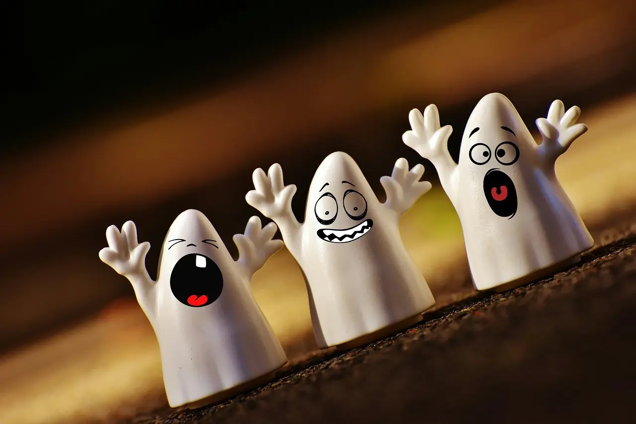 Three small ghost figures made from plastics, like toys.